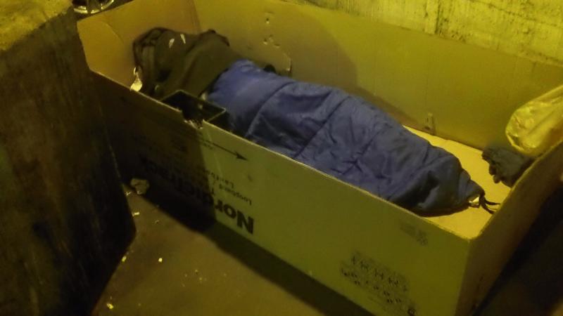 Homeless Person living in a cardboard box under lower wacker in city of Chicago,